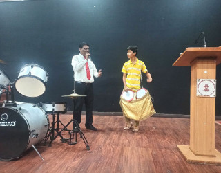 Student performing on the stage with the Trainer